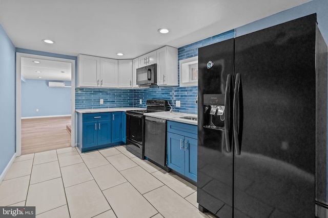 kitchen with black appliances, light countertops, blue cabinetry, white cabinetry, and tasteful backsplash