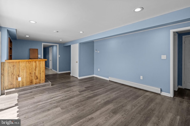unfurnished living room with a baseboard heating unit, wood finished floors, recessed lighting, baseboards, and a dry bar