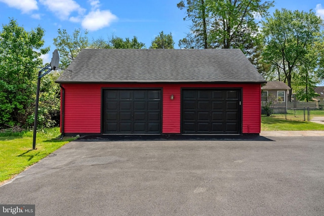 detached garage featuring fence