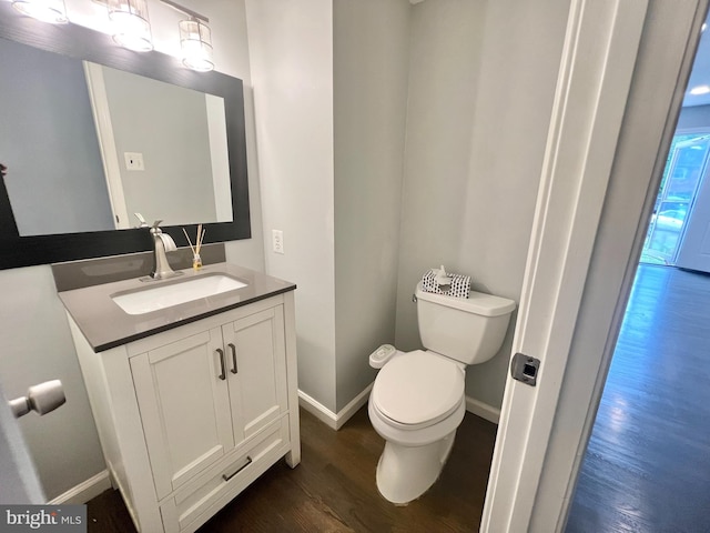 bathroom featuring wood finished floors, vanity, toilet, and baseboards