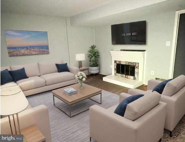 living area with a fireplace with raised hearth and wood finished floors