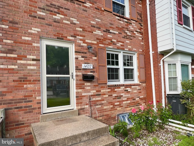 doorway to property featuring brick siding