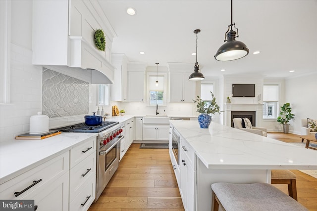 17 W Redman Ave, Haddonfield, NJ 08033 - kitchen with stainless steel appliances, a sink, a kitchen island, light wood-style floors, and a kitchen breakfast bar