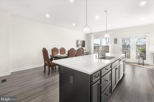 6034 Goshawk St, New Market, MD 21774 - kitchen featuring a sink, dark wood-type flooring, light countertops, a kitchen island with sink, and pendant lighting