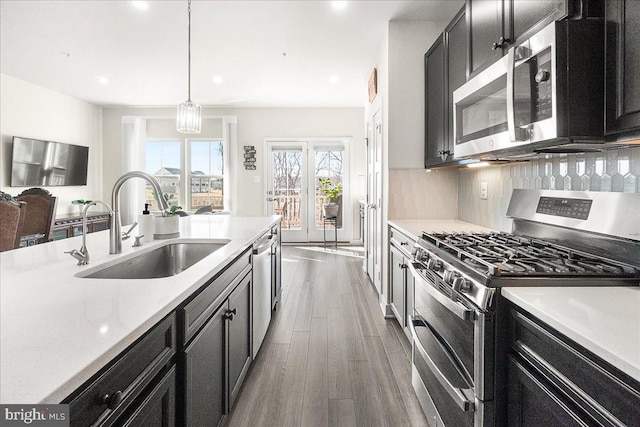 6034 Goshawk St, New Market, MD 21774 - kitchen featuring appliances with stainless steel finishes, a sink, dark cabinets, light countertops, and recessed lighting