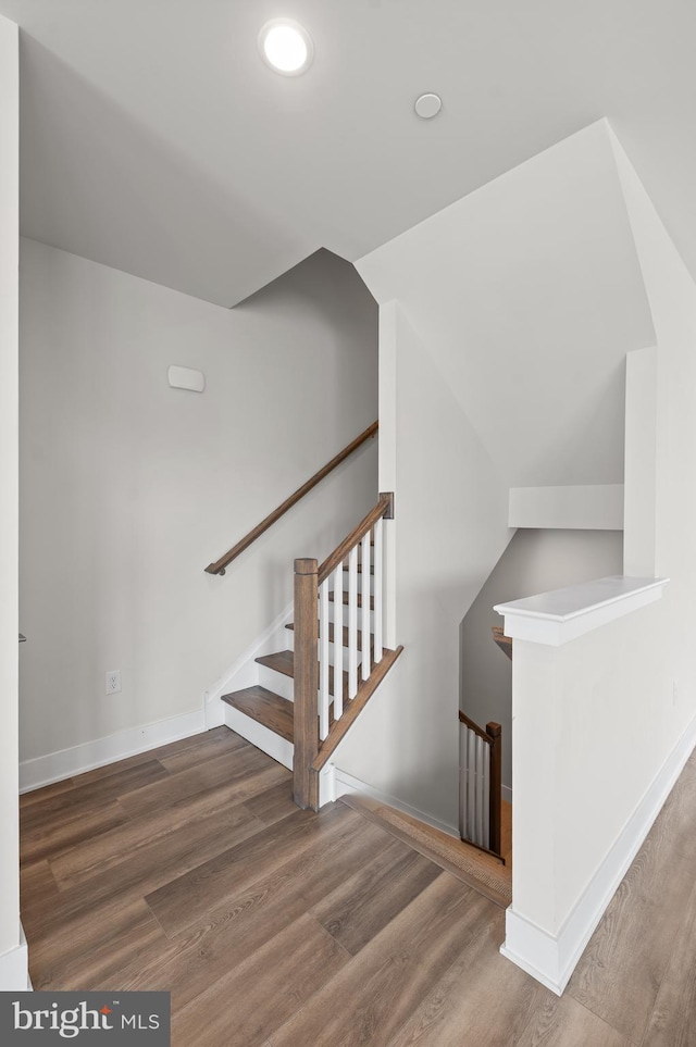 stairs with wood finished floors, baseboards, recessed lighting, and lofted ceiling