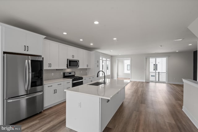 kitchen featuring stainless steel appliances, a sink, an island with sink, white cabinetry, and recessed lighting