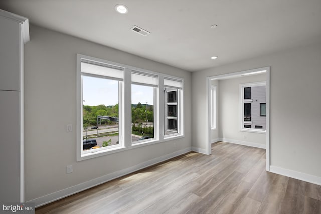 unfurnished room featuring recessed lighting, light wood-type flooring, and baseboards