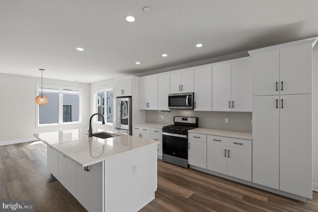 kitchen featuring stainless steel appliances, a sink, dark wood-style floors, tasteful backsplash, and white cabinetry