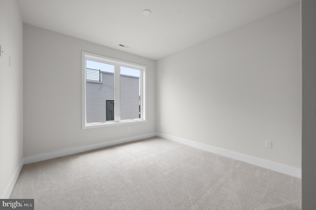 unfurnished room featuring carpet and baseboards