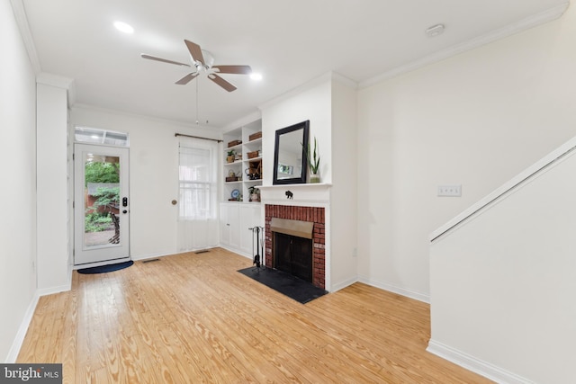 1215 Walter St SE, Washington, DC 20003 - unfurnished living room with ceiling fan, crown molding, a fireplace, light wood-style flooring, and baseboards