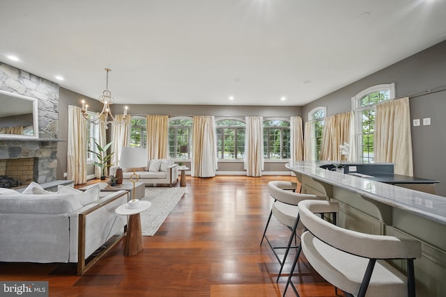 43582 Old Kinderhook Dr, Ashburn, VA 20147 - living area with wood finished floors, a chandelier, a stone fireplace, and recessed lighting