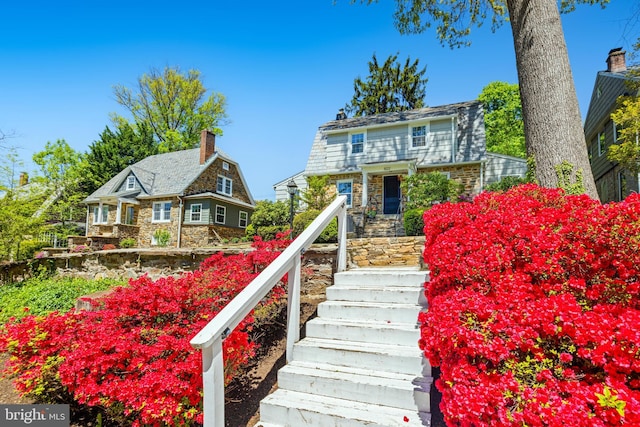 view of front of property featuring stone siding and stairway