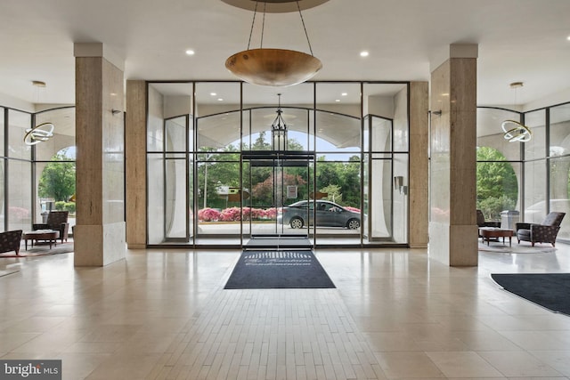 common area with expansive windows, a towering ceiling, and recessed lighting