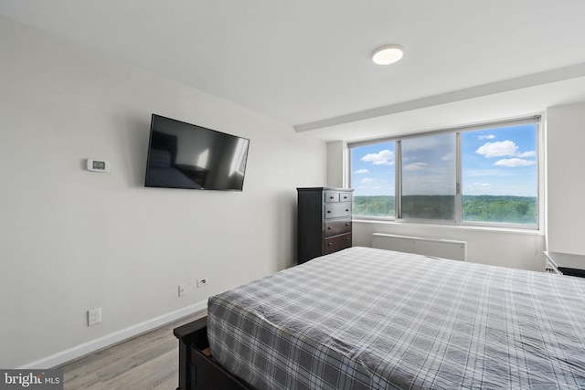 bedroom with light wood-style flooring and baseboards