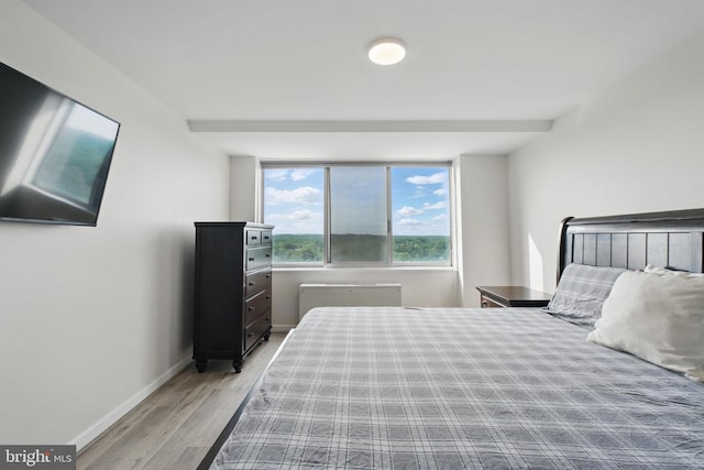 bedroom with wood finished floors and baseboards