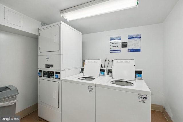 communal laundry room featuring stacked washing machine and dryer, baseboards, and washer and clothes dryer