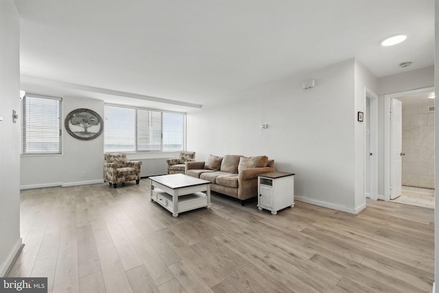 living area with light wood-type flooring and baseboards