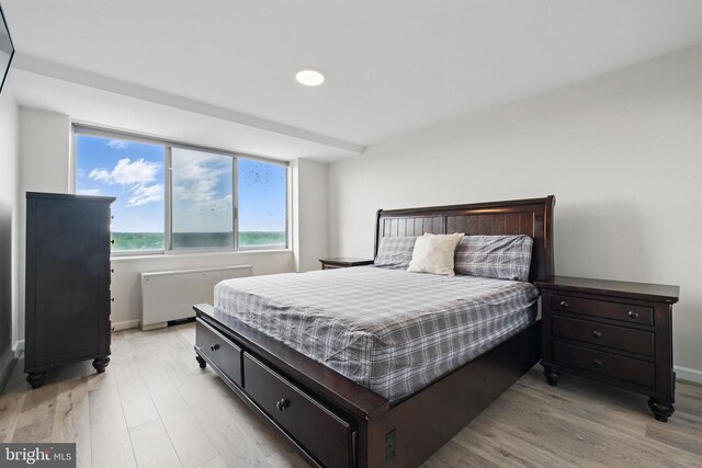 bedroom featuring radiator, light wood-style flooring, baseboards, and recessed lighting