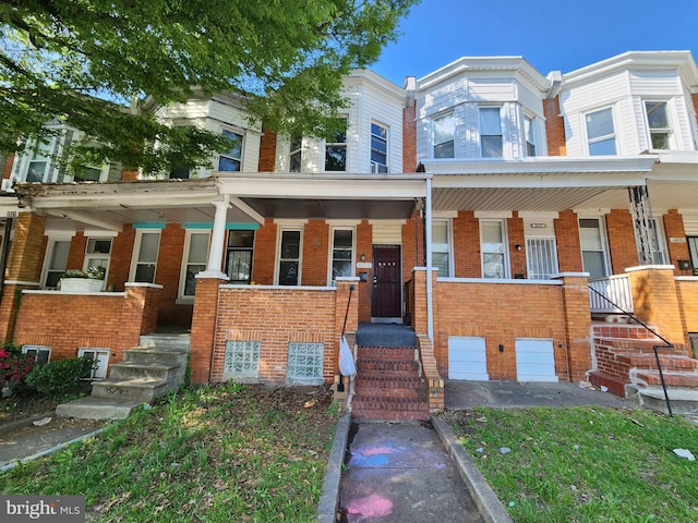 view of property with covered porch and brick siding