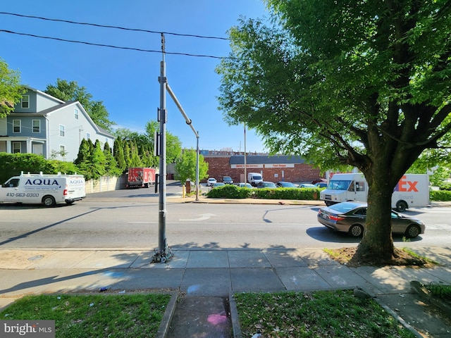 view of asphalt road with curbs and sidewalks