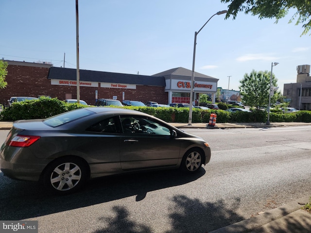 view of asphalt road featuring sidewalks, curbs, and street lights