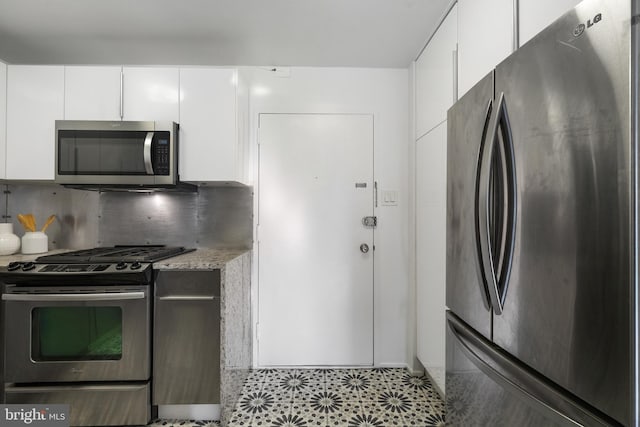 1250 4th St SW Unit W203, Washington, DC 20024 - kitchen featuring appliances with stainless steel finishes, white cabinetry, tasteful backsplash, and light stone counters