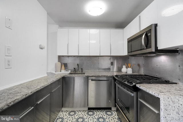 1250 4th St SW Unit W203, Washington, DC 20024 - kitchen featuring stainless steel appliances, a sink, white cabinets, tasteful backsplash, and light stone countertops