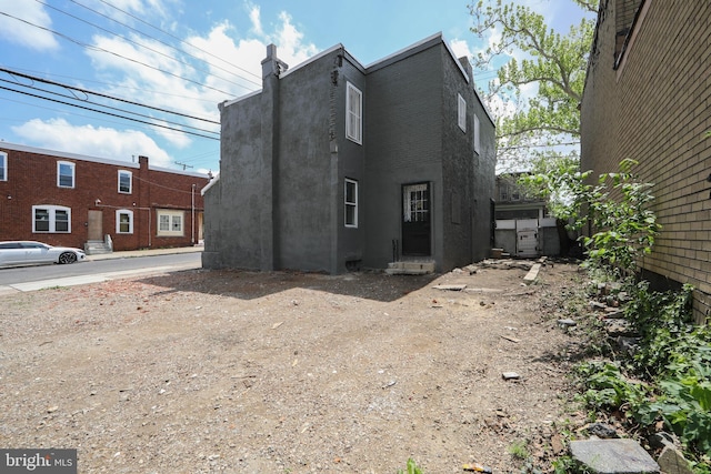 view of side of home featuring stucco siding and a chimney