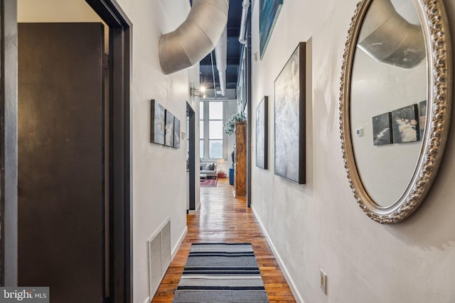 corridor with wood finished floors and baseboards