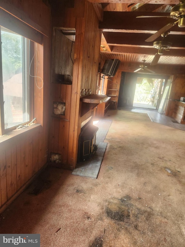 5573 Rte 9, Tuckerton, NJ 08087 - unfurnished living room featuring wood walls, a wood stove, carpet, and a ceiling fan