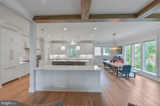 302 Jade Ct NW, Vienna, VA 22180 - kitchen featuring a spacious island, light countertops, backsplash, white cabinetry, and light wood-style flooring