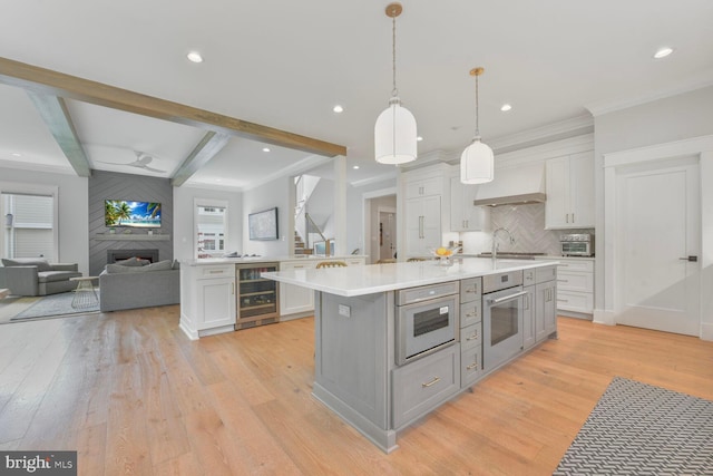 302 Jade Ct NW, Vienna, VA 22180 - kitchen featuring wine cooler, wall oven, light countertops, custom exhaust hood, and light wood finished floors