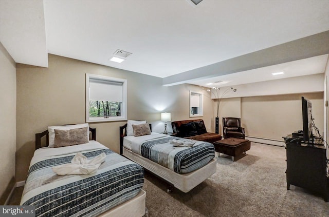 carpeted bedroom with baseboard heating and baseboards