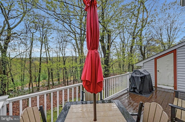 wooden deck featuring area for grilling and outdoor dining area