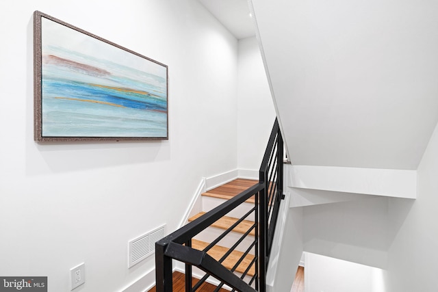staircase featuring baseboards and wood finished floors