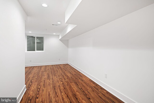 additional living space with recessed lighting, dark wood-style floors, and baseboards