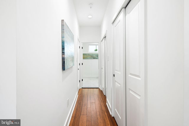 hallway with dark wood-style floors and baseboards