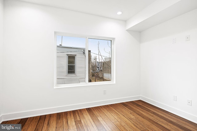 unfurnished room with baseboards, wood-type flooring, and recessed lighting