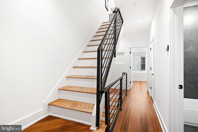 stairway with hardwood / wood-style flooring and baseboards