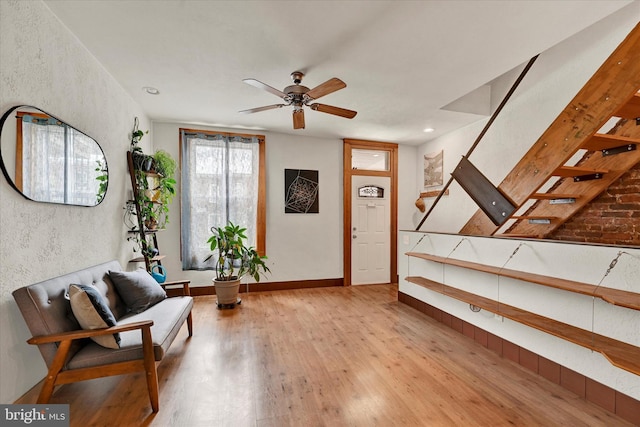 foyer entrance featuring stairway, light wood-type flooring, and a ceiling fan