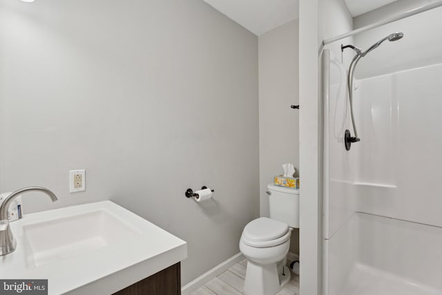 full bathroom with a shower stall, toilet, a sink, and baseboards