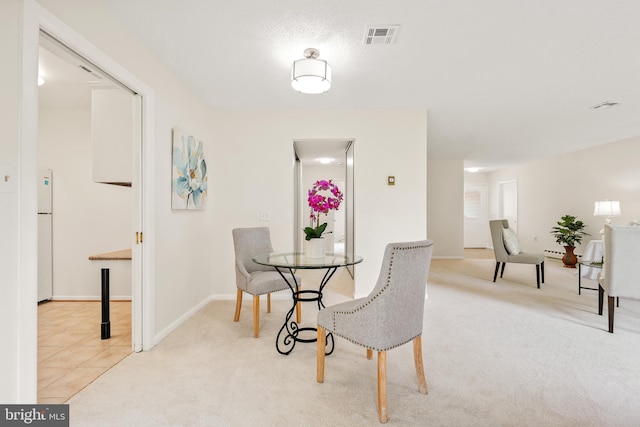 carpeted dining space featuring baseboards