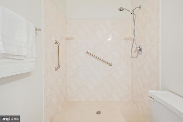 bathroom with toilet and tiled shower