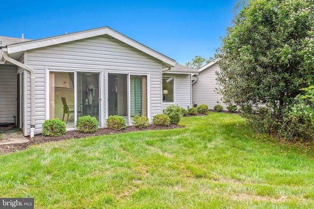back of property featuring a lawn