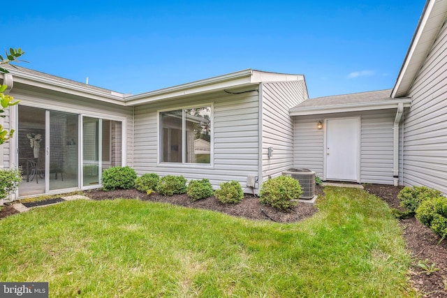 doorway to property with central AC and a yard