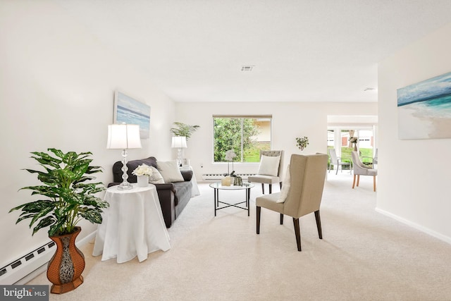carpeted living area with baseboard heating and baseboards