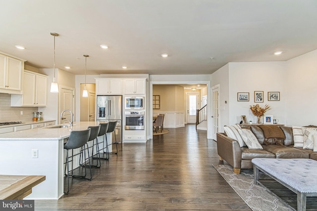 718 Quarry Point Rd, Malvern, PA 19355 - kitchen with appliances with stainless steel finishes, a sink, a breakfast bar area, open floor plan, and dark wood-style floors