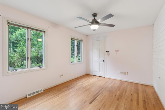 unfurnished room with light wood finished floors, baseboards, and a ceiling fan