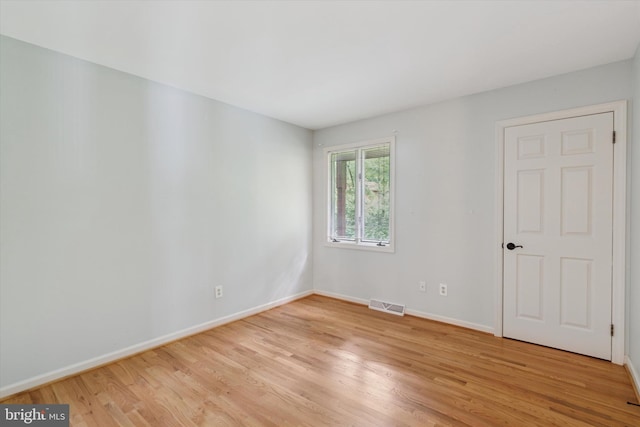 spare room featuring light wood-type flooring and baseboards